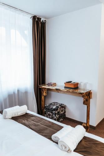 a room with a bed and a table with towels at Casa Rosu in Cluj-Napoca