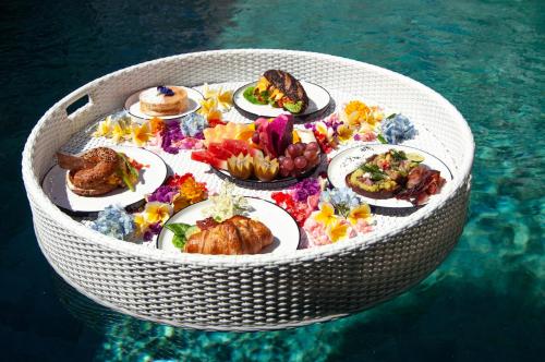 a circular table of food in the water at La Boutique villas Seminyak Bali in Seminyak