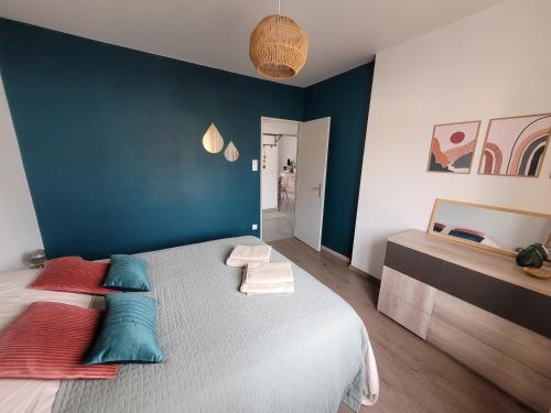 une chambre avec un grand lit aux murs bleus dans l'établissement Charmante maison à Stotzheim, 1 à 6 personnes, à Stotzheim