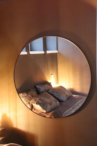 un miroir sur un mur avec un lit dans une chambre dans l'établissement Les Secrets du Château - Love Room, à Lichtenberg