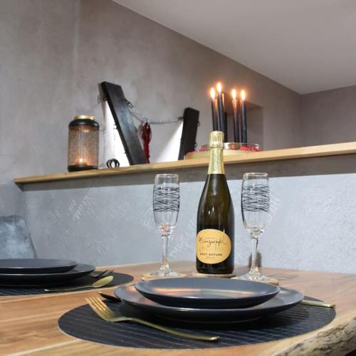 - une table avec une bouteille de vin et deux verres dans l'établissement Les Secrets du Château - Love Room, à Lichtenberg