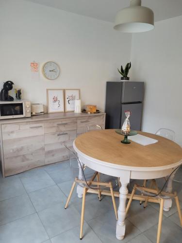 une cuisine avec une table, des chaises et un réfrigérateur dans l'établissement Charmante maison à Stotzheim, 1 à 6 personnes, à Stotzheim