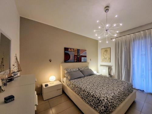 a bedroom with a bed and a chandelier at Pretty Home in Acireale