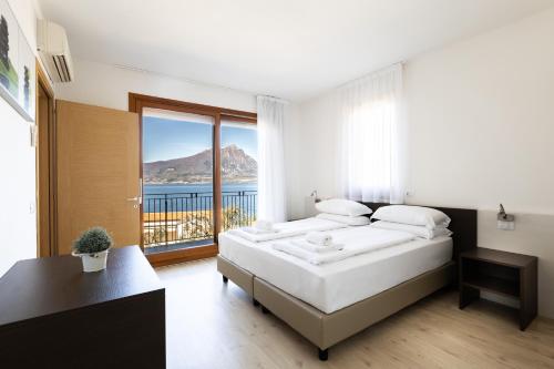ein Schlafzimmer mit einem großen Bett und einem großen Fenster in der Unterkunft Residence La Corte Danese in Torri del Benaco