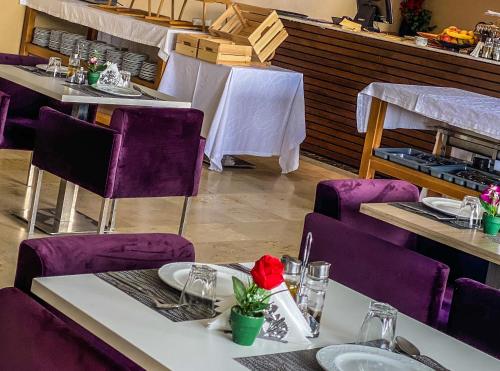a dining room with purple chairs and tables with tablesktop at Prestige Hotel & Spa in Tetouan