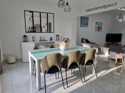 a dining room with a blue table and chairs at La Désirade Audresselles, charmante maison à 250 m de la plage in Audresselles