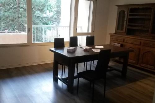 une salle à manger avec une table et des chaises et une fenêtre dans l'établissement Location T4 85M², à Lyon
