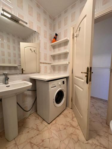 a bathroom with a washing machine and a sink at Alquilaencanarias- Medano Amanecer Cabezo Beach in El Médano