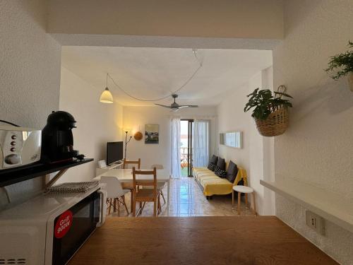 eine Küche und ein Wohnzimmer mit einem Tisch und einem Sofa in der Unterkunft Alquilaencanarias- Medano Amanecer Cabezo Beach in El Médano