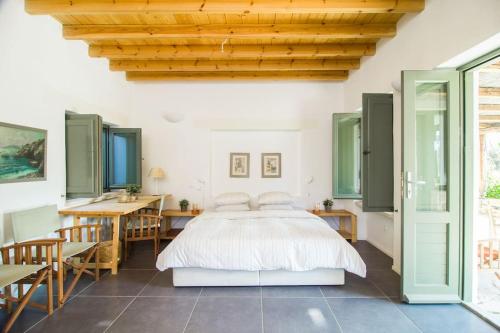a bedroom with a bed and a table and chairs at Oleander Country House in Patmos