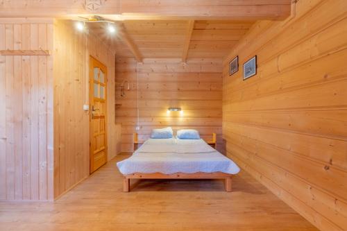 a bedroom with a bed in a wooden room at Domek Góralski Na Pastwisku in Małe Ciche