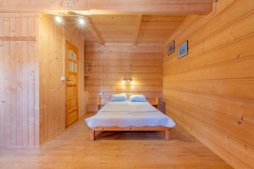 マウェ・チヘにあるDomek Góralski Na Pastwiskuの木製の部屋にベッド1台が備わるベッドルーム1室があります。