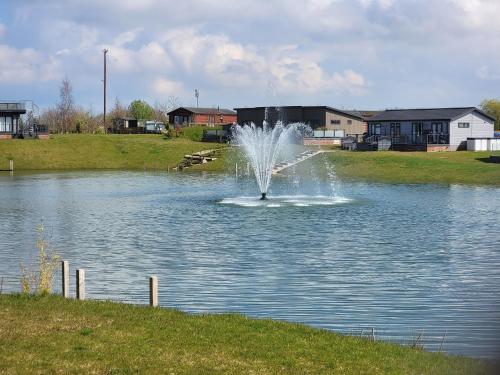 a fountain in the middle of a pond at Luxury 2-Bed Lodge in Routh HotTub & Pet Friendly in Routh