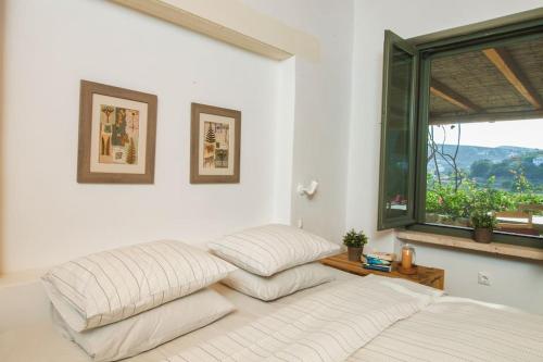 two beds in a room with a window at Oleander Country House in Patmos