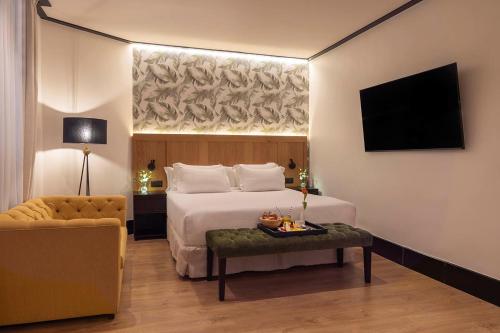 a hotel room with a bed and a chair at H10 Puerta de Alcalá 4 Sup in Madrid