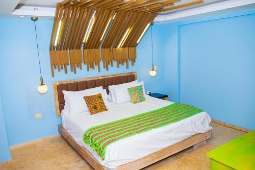 a bedroom with a large bed with blue walls at Coco Beach Hotel - Rooftop & Beach Club in Cartagena de Indias