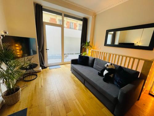 巴黎的住宿－Le refuge du 15，客厅配有长沙发,上面有熊猫