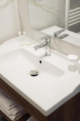 a bathroom with a white sink and a mirror at Hotel Măgura Jina in Jina