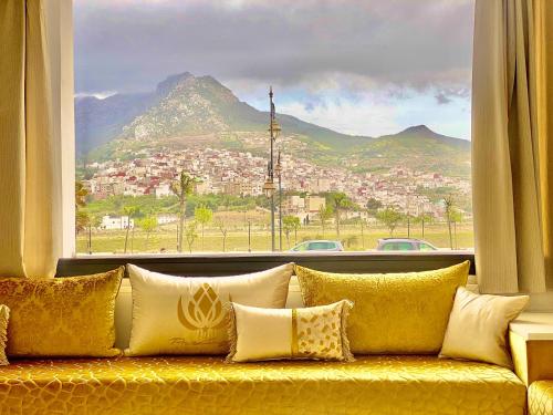 a yellow couch in front of a window with a view at Prestige Hotel & Spa in Tetouan