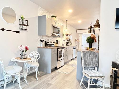 uma cozinha com armários brancos e uma mesa e cadeiras em Time Travel Inn em Birnamwood