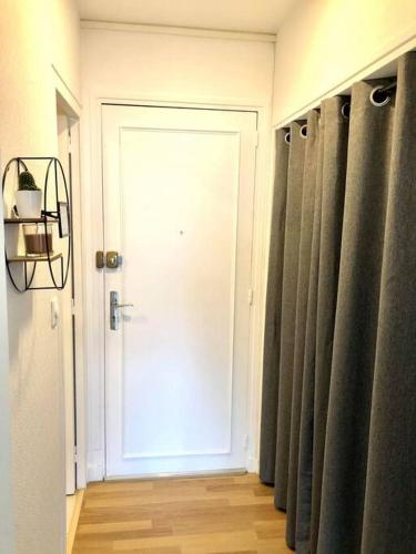 - une porte dans une chambre avec des rideaux dans un couloir dans l'établissement Studio les pieds dans l'eau, au Pouliguen