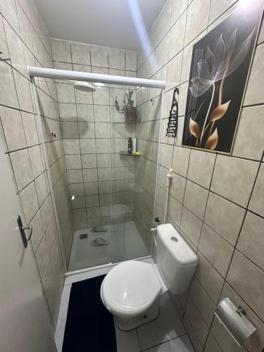 a small bathroom with a toilet and a shower at Cantinho aconchegante - Quarto 02 AR-condicionado in Bayeux