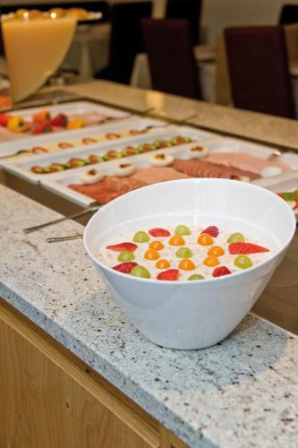 a bowl of cereal with fruit on a counter at Hotel Garni Rauch in Sankt Anton am Arlberg
