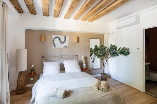 een slaapkamer met een groot wit bed met handdoeken erop bij Pavillon Eden « Le cocon » in Parijs