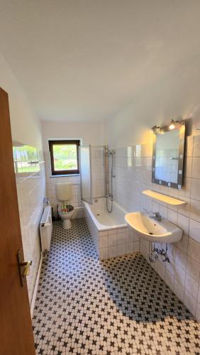 a bathroom with a tub and a sink and a toilet at MonteurzimmerKING Hunteburg Am Amtshaus in Bohmte