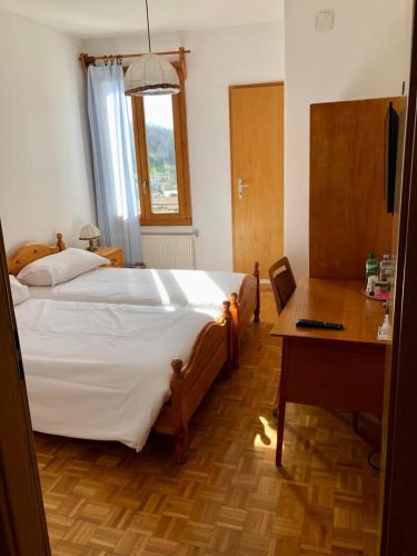 - une chambre avec un lit, un bureau et une table dans l'établissement Ristorante Bar Pensione Novaggio, à Novaggio