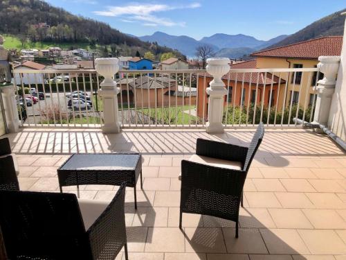 un patio con tavolo e sedie sul balcone. di Ristorante Bar Pensione Novaggio a Novaggio