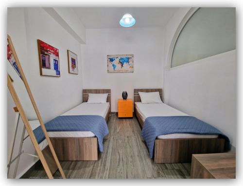 a room with two beds and a mirror at Welcome Home Syros Port Apartment in Ermoupoli