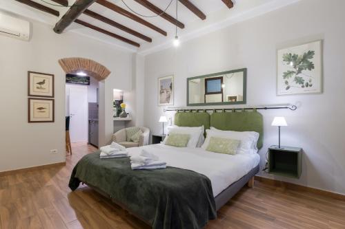 um quarto com uma cama grande com cabeceira verde em Rome as you feel - Piazza dei Satiri apartments em Roma