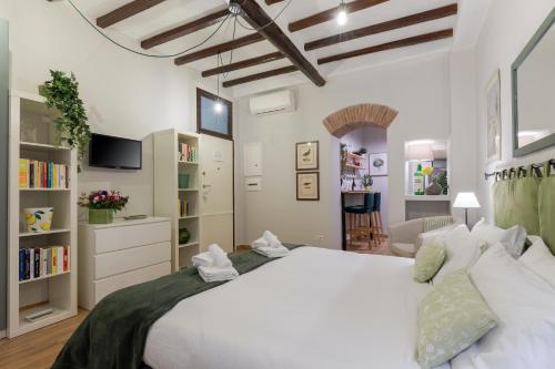 ローマにあるRome as you feel - Piazza dei Satiri apartmentsのベッドルーム(大きな白いベッド1台付)、リビングルームが備わります。