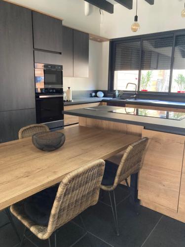 a kitchen with a wooden table and some chairs at Le 51 bis in Châteauroux