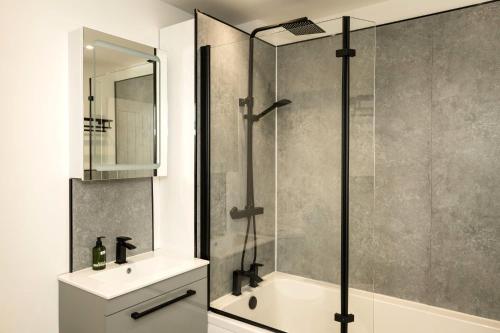 une salle de bain avec douche et lavabo dans l'établissement Pier View - stylish flat with sea views, à Eastbourne