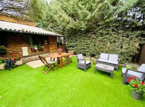 a backyard with a table and chairs and grass at Cabaña ecologica del lago in Paredes de Buitrago