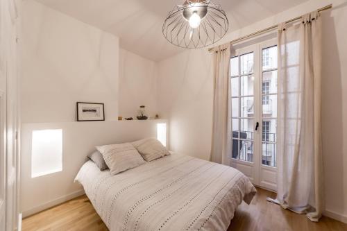 ein Schlafzimmer mit einem Bett und einem großen Fenster in der Unterkunft Elegance and high standing in the city center in Lyon