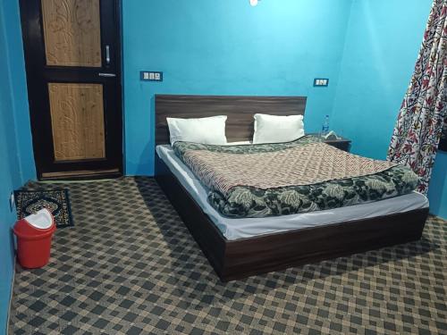 - une chambre dotée d'un lit avec un mur bleu dans l'établissement Apple Garden View and Restaurant, à Pahalgām