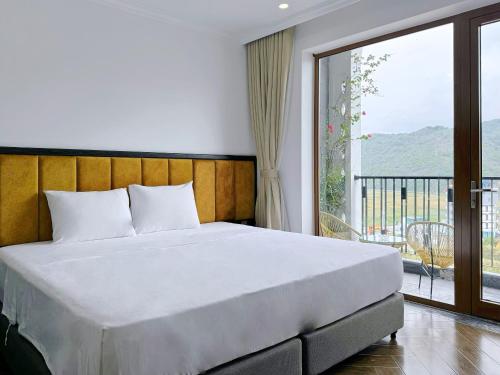 a bedroom with a large bed and a balcony at Eden Hotel Cát Bà in Cat Ba