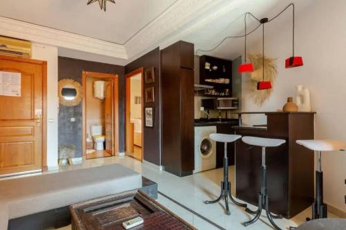 uma cozinha com um balcão e um bar com bancos em Joli appartement centre Gueliz em Marrakech