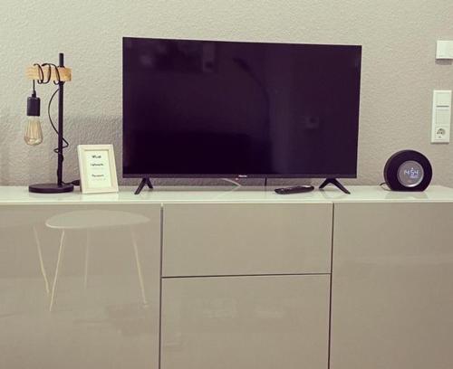 a television sitting on top of a white cabinet at Ankertau in Norden