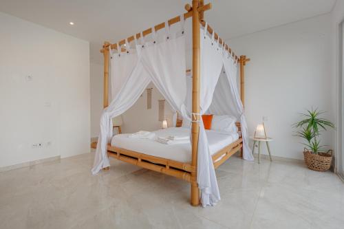 een slaapkamer met een hemelbed en een baldakijn bij Inspiration Villa in Ribamar