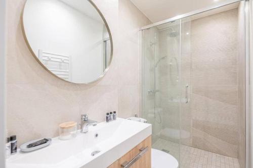 une salle de bain avec un lavabo et une douche avec un miroir dans l'établissement Appartement design avec jardin privatif, à Paris