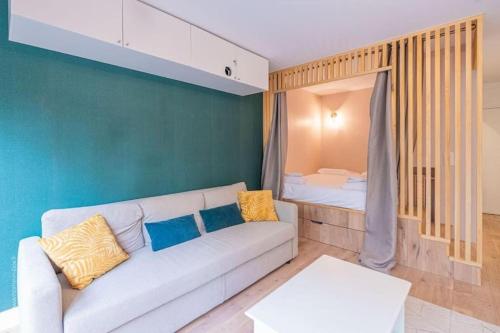 un salon avec un canapé et un lit dans l'établissement Appartement design avec jardin privatif, à Paris