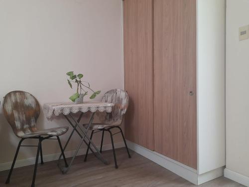 uma mesa e duas cadeiras num quarto em Habitación privada en apto cat friendly em Montevidéu