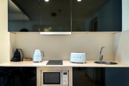 a kitchen counter with a sink and a microwave at Limonaia in Barcelona