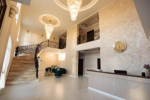 a lobby with a staircase and a clock on the wall at Hotel Măgura Jina in Jina