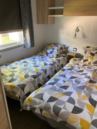 une chambre avec deux lits et une fenêtre dans l'établissement MOBILE HOME CLIMATISE Vias 2, à Vias