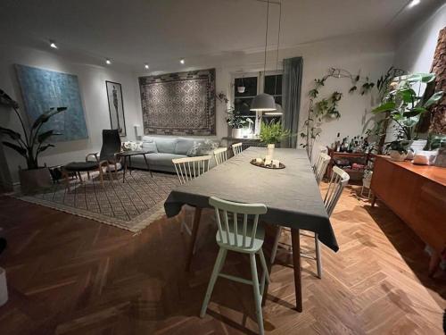uma sala de estar com uma mesa e cadeiras e um sofá em Stor etage St knut em Malmo